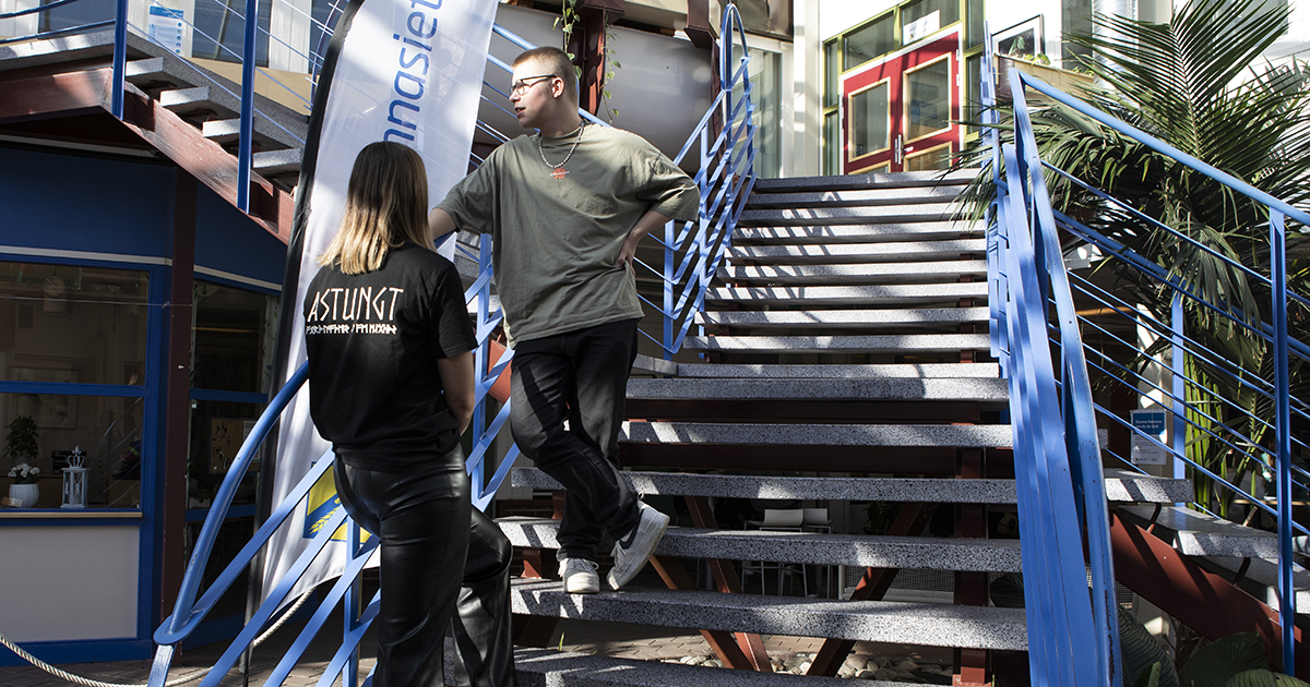 Två personer som står i en trappa och pratar.